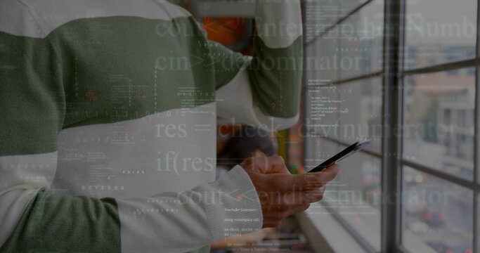 Developer in striped sweater examining smartphone while raising hand in office with code overlay