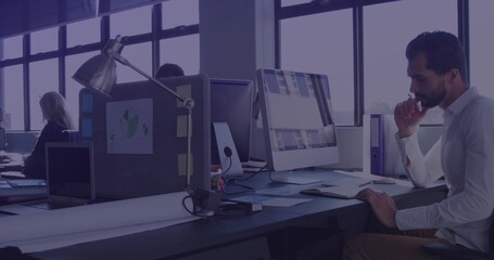 Leaning Middle Eastern man focusing on screen in open plan office with mouse, copy space