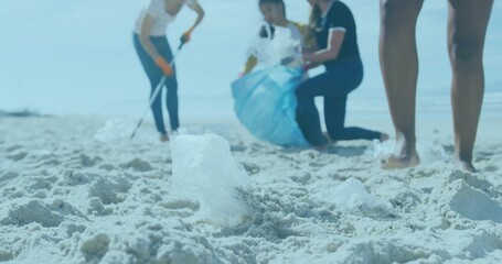 Volunteers collecting plastic debris on beach, with translucent bag fragment using gloves