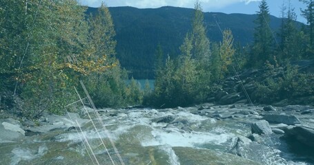 Rushing whitewater rapids cascading over river rocks in mountain stream, with lake and forest