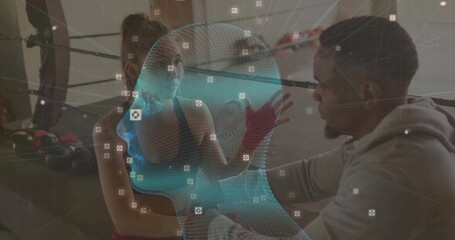 Trainer kneeling adjusting hand wraps on sports-bra athlete on bench in boxing ring, mesh overlay