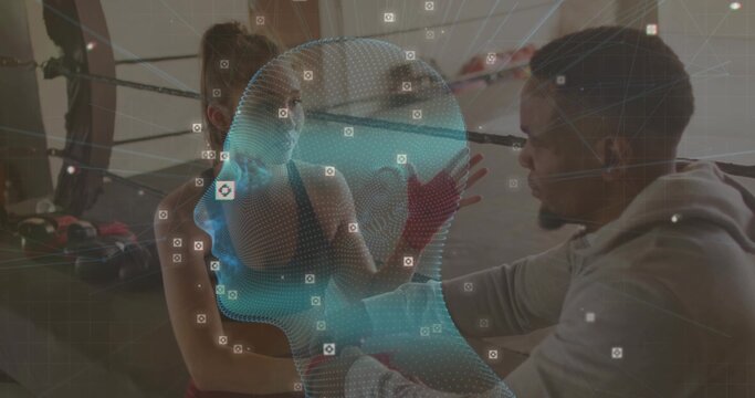 Trainer kneeling adjusting hand wraps on sports-bra athlete on bench in boxing ring, mesh overlay