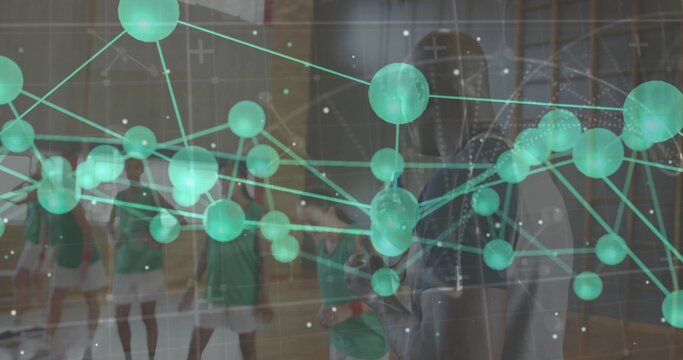 Standing athletes in green jerseys with rackets and coach gesturing on court, showing data overlay