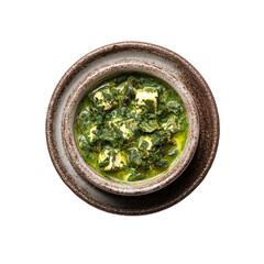 Palak paneer in a rustic ceramic bowl, top view, isolated on white background.
