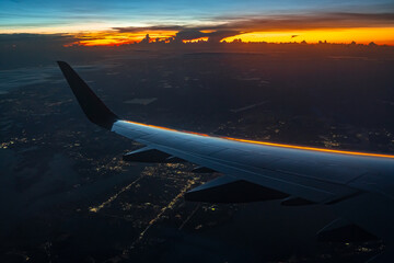 Sunrise view from airplane window above the clouds
