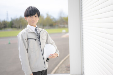 ヘルメットを持った作業員男性