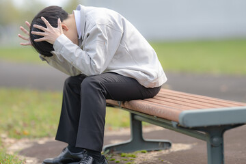 頭を抱える作業服男性