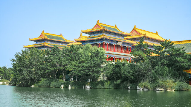 Traditional Chinese temple in Penglai, Shandong, with red pillars, golden roofs, and ornate details, surrounded by lush greenery and a serene natural setting.