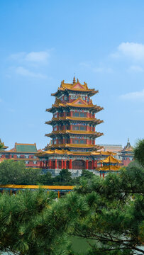 Traditional Chinese temple in Penglai, Shandong, with red pillars, golden roofs, and ornate details, surrounded by lush greenery and a serene natural setting.