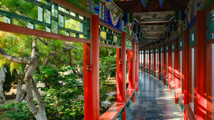 Traditional Chinese temple in Penglai, Shandong, with red pillars, golden roofs, and ornate details, surrounded by lush greenery and a serene natural setting.