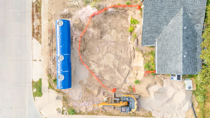 Aerial view of a construction site installing a new underground storage tank at a gas station.