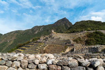 Machu Picchu’s terraces and stone walls in Cusco, Peru, surrounded by Andean mountains. UNESCO World Heritage site and famous Inca landmark.
