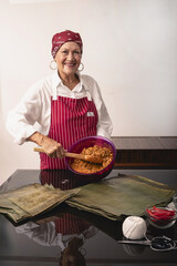 Senior woman proudly holds hallaca filling, ready for traditional cooking