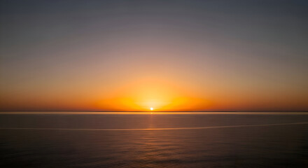 Fototapeta premium Golden Sunrise Reflecting on Calm Ocean Water