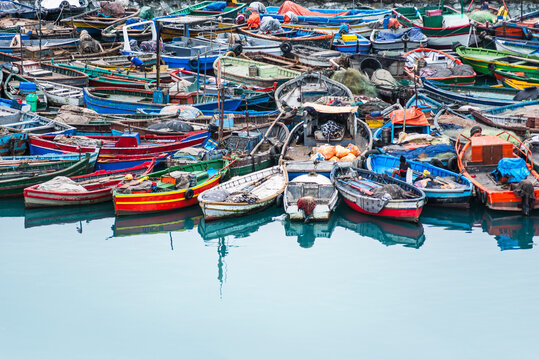 Colorful wooden fishing boats are tightly moored together in Callao, Peru. 