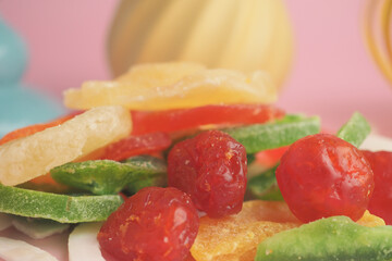 Colorful dried fruit assortment on a pink background
