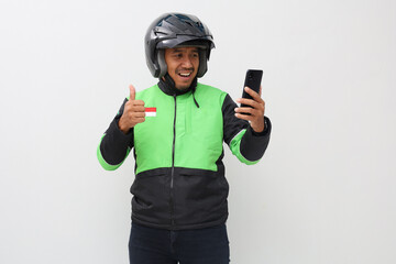 Asian man work as a commercial motorcycle taxi driver taking order from his smart phone while giving thumb up