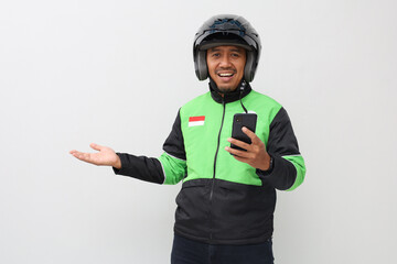 Asian man online driver holding smart phone and presenting aside to empty space