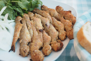Crispy fried fish served with fresh herbs and vegetables