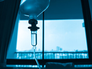 Medical infusion pump with digital screen displaying flow rate in a hospital room. Pediatric patient resting in bed in the background. Healthcare and intravenous therapy concept.