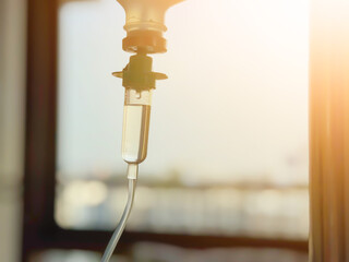 Medical infusion pump with digital screen displaying flow rate in a hospital room. Pediatric patient resting in bed in the background. Healthcare and intravenous therapy concept.