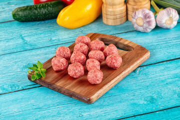 Raw beef meatballs over board