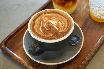 Cappuccino it's a mix between coffee and milk. Draw an artistic pattern on the cream foam.