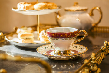 Fototapeta premium Ornate teacup and saucer at a luxurious blurred afternoon tea service