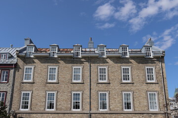 Obraz premium A view in summer of the Old Quebec in Canada with ancient architecture. Ancient building with stone facade and rusty old roof . Historic building in Quebec city in Canada.
