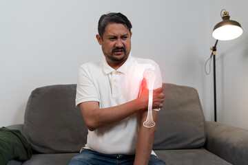 Man suffering shoulder pain injury with highlighted bone illustration showing joint problem and...