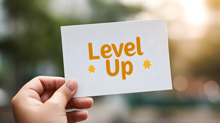 A hand holding a card with the phrase Level Up