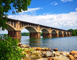 Fototapeta premium Bridge over river with trees and clouds