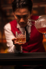 Bartender is pouring whiskey into a glass in a restaurant	