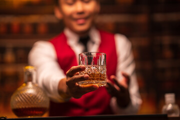 Bartender is pouring whiskey into a glass in a restaurant