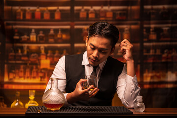 Business man bartender pours whiskey into a glass, sitting sadly in a restaurant