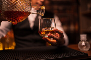 Bartender is pouring whiskey into a glass in a restaurant	
