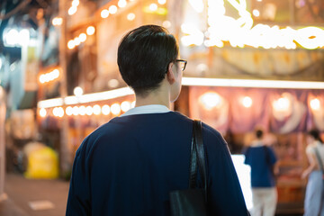 夜の飲み屋街を歩く男性の後姿