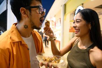 Happy couple sharing takoyaki in a food court © Franci Leoncio