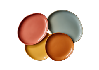Stacked colorful plates in shades of peach, light blue-gray, mustard yellow, and terracotta