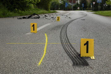Forensic crash scene investigation with tire marks and evidence markers on road, highlighting aftermath of accident. scene evokes sense of urgency and need for analysis