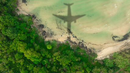 Aerial view of shadow passenger plane silhouette and sandy beach blue sea with waves at sea beach summer vacation sea travel concept	
