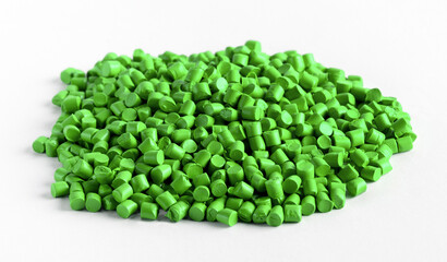 Green plastic granules forming a small pile on a white background