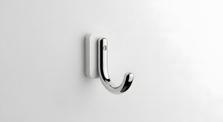 A chrome hook with a white adhesive backing, mounted on a plain white wall.