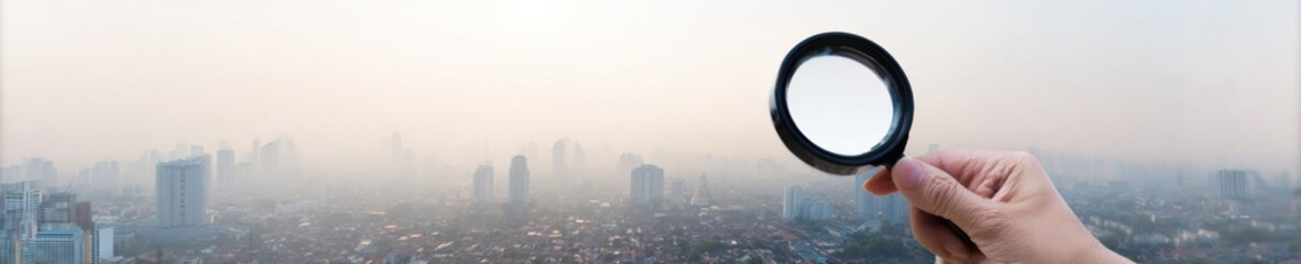 Professional air quality monitoring with magnifying glass over smog cityscape, modern environmental health concept for corporate marketing campaigns