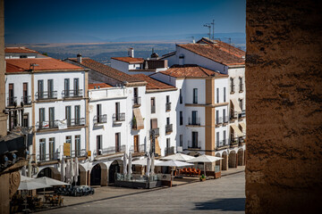 Vista panorámica del casco histórico de la ciudad española de Cáceres con vistas a los tejados de tejas marrones de edificios antiguos alrededor de la plaza principal en el soleado día de verano