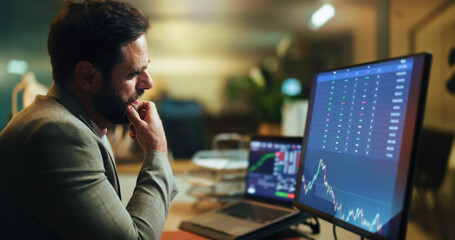 Businessman, thinking and night with stock market screen for monitoring graph, statistics or data. Man, broker or trader working late with computer display or chart for analytics or virtual exchange