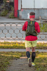 A man runs along a park path on an autumn day
