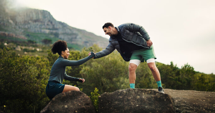 Couple, helping hand and rock climb with mountain for hiking trail, exercise or outdoor fitness. Man, woman or assistance with lift on cliff for trekking journey or adventure together in nature - Powered by Adobe