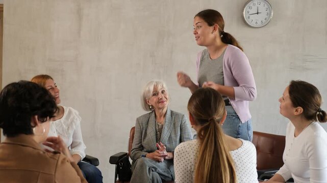 Positive young girl participating in volunteer organization talking with interest about new project to group of female partners of different ages during informal meeting