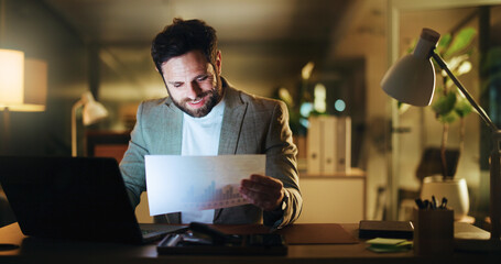 Laptop, reading and documents with business man in office for night, account graph and research....